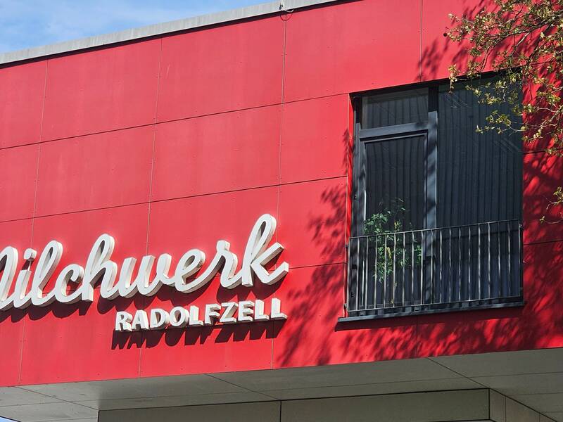 Ein rotes Gebäude mit der Aufschrift "Milchwerk Radolfzell" und einem Fenster ist zu sehen.
