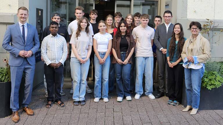 Die vierzehn jungen Menschen des Jugendgemeinderates stehen mit Oberbürgermeister Simone Gröger und Bürgermeisterin Monika Laule freundlich lächelnd vor dem Rathaus für ein Gruppenfoto zusammen.