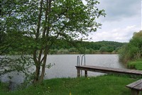  Buchenseebad Güttingen, See mit Steg um den See befinden sich Bäume 